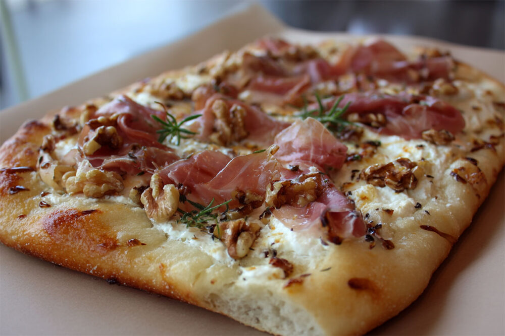 Pinsa med prosciutto, creme fraiche, honung och rostade nötter