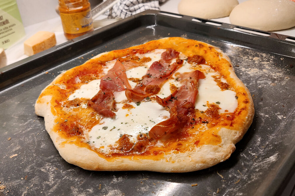 Pizza med lufttorkad skinka (prosciutto) och röd pesto