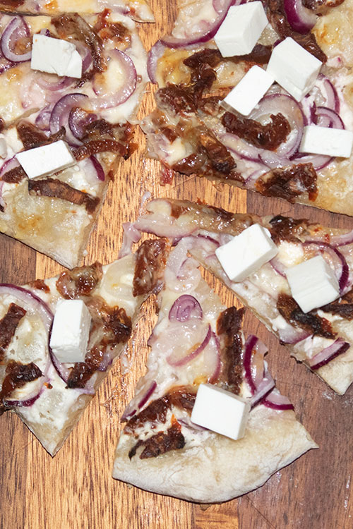 Snittar med soltorkade tomater, rödlök och vitost